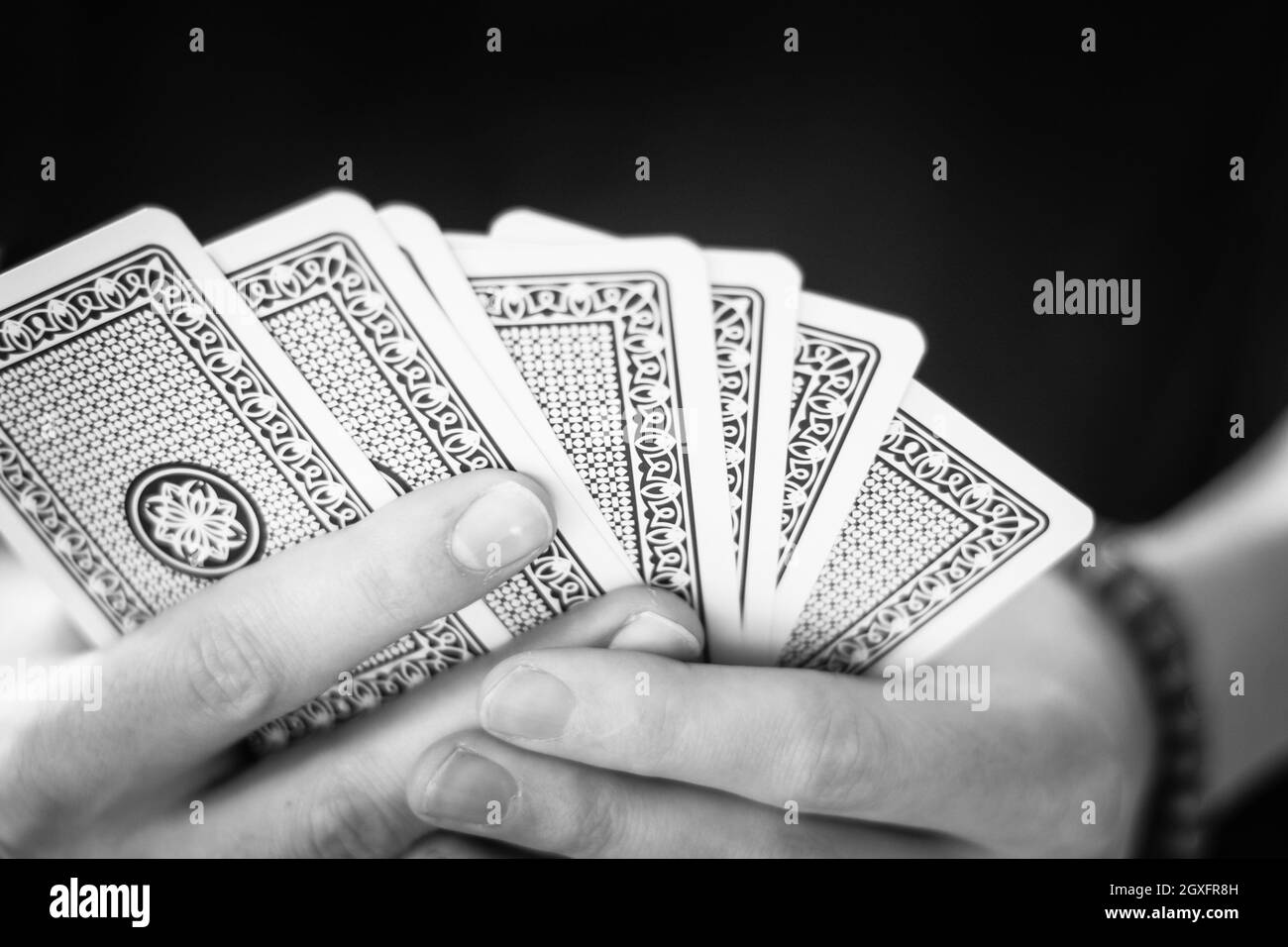 Giovane uomo è giocando a carte, spaccato di sue mani Foto Stock