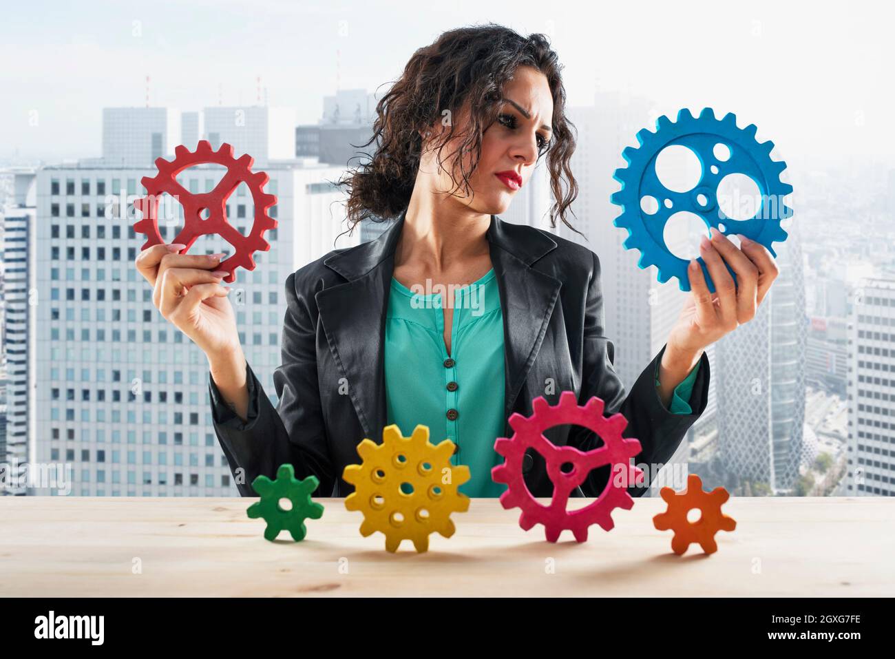 Businesswoman cerca di lavorare con il sistema di ingranaggi. Concetto di lavoro di squadra e partnership Foto Stock