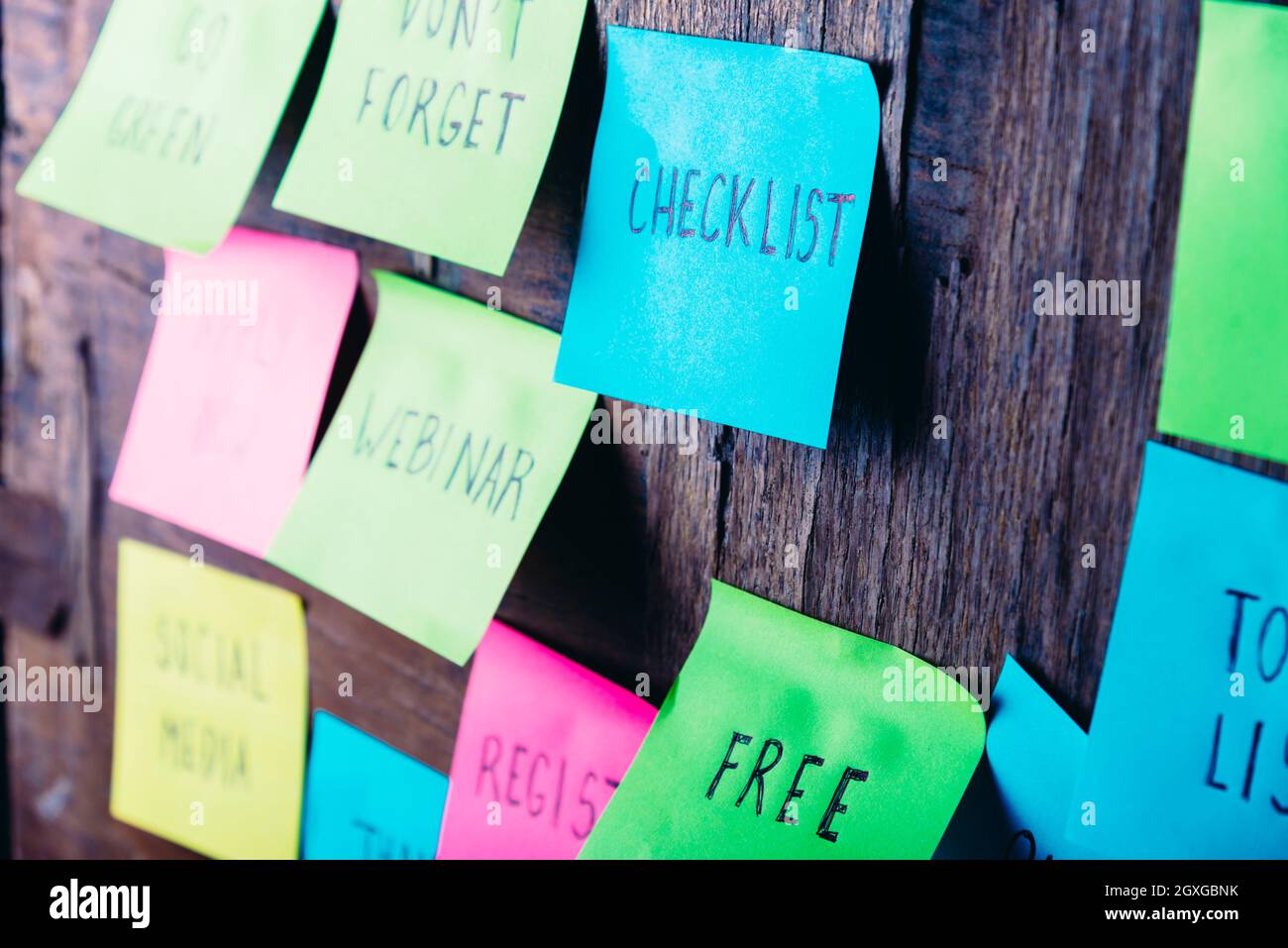 Note colorate appiccicose sul promemoria in legno. Lista di controllo gratuita dei webinar per i social media registrazione adesivo scritto su pineboard. Elenco di controllo e elenco di attività r Foto Stock