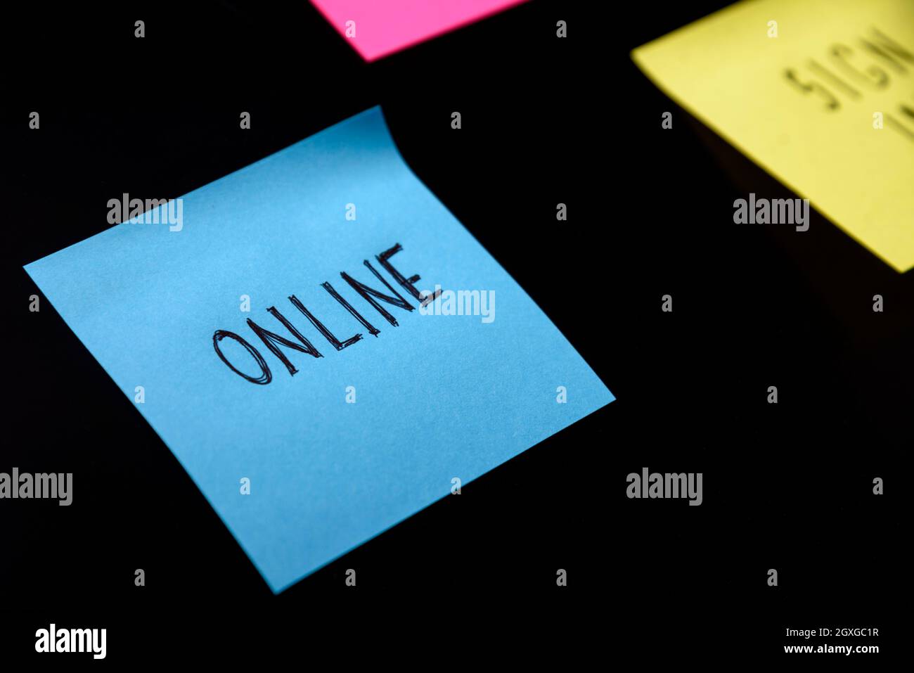 Note colorate appiccicose sul promemoria della lavagna nera. Adesivo online scritto su pineboard. Concetto di business digitale e online. Foto Stock