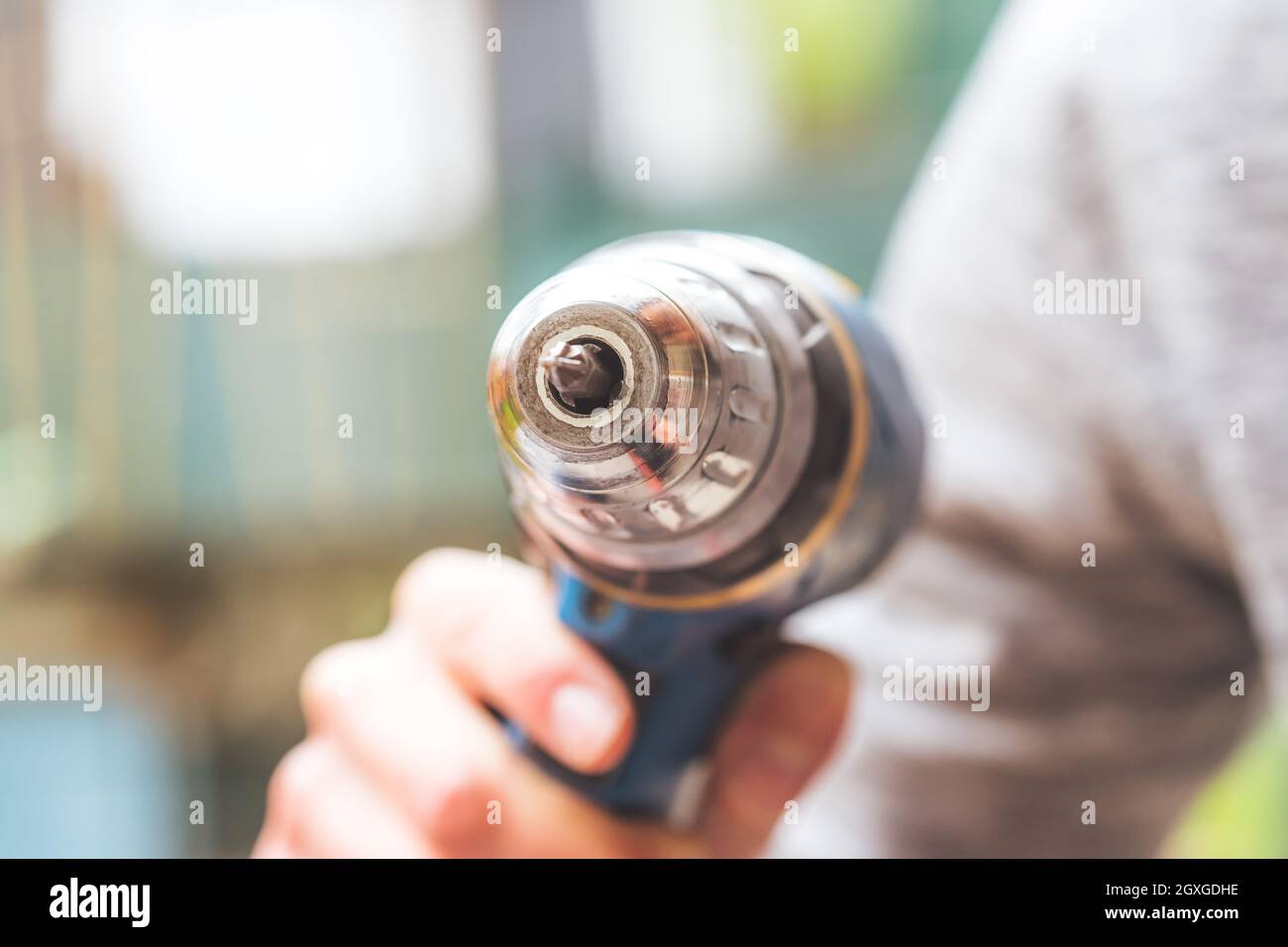 Fai da te il manipolo di casa sta tenendo un cacciavite cordless, all'aperto Foto Stock