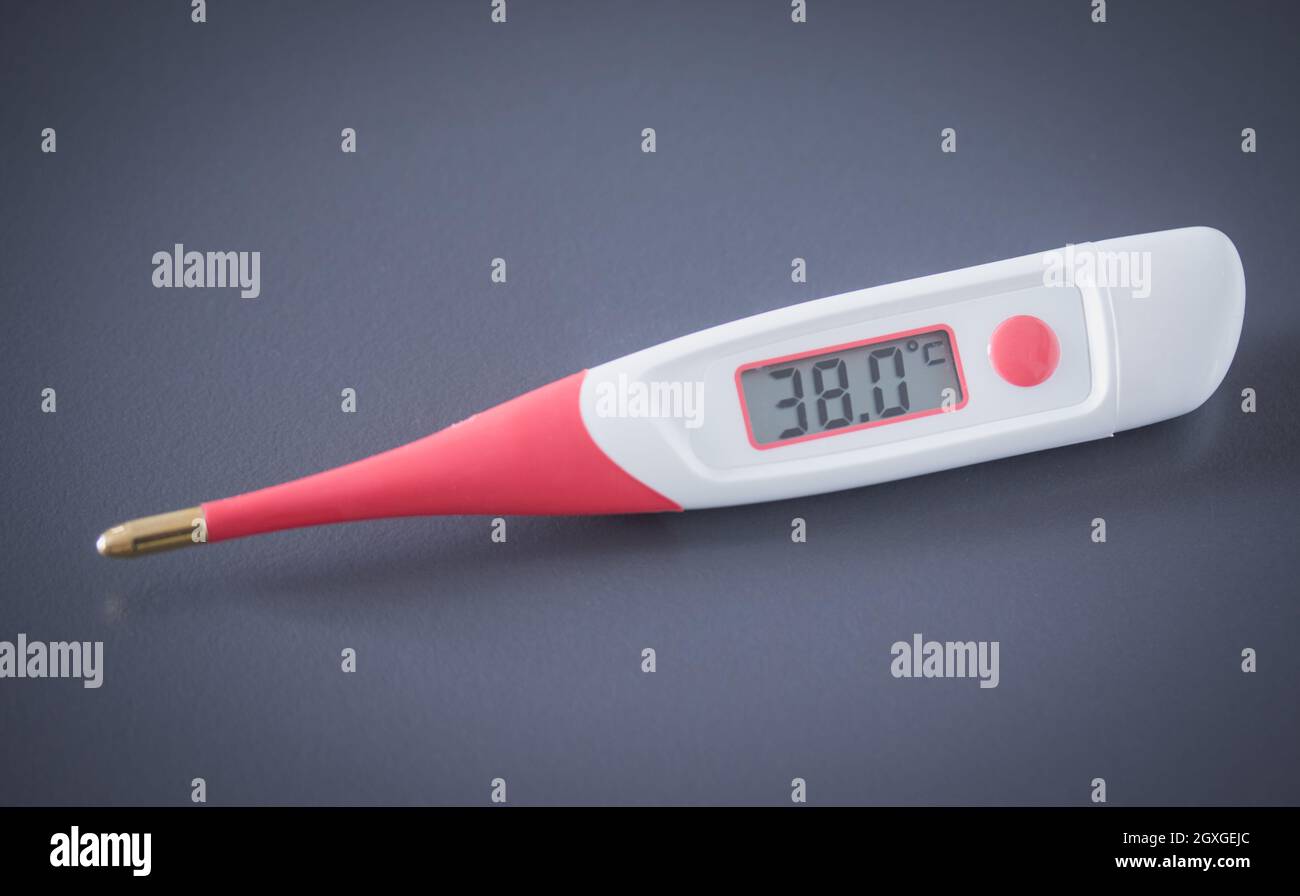 Termometro di febbre e pillole sulla scrivania, 38 gradi Celsius sul  display Foto stock - Alamy