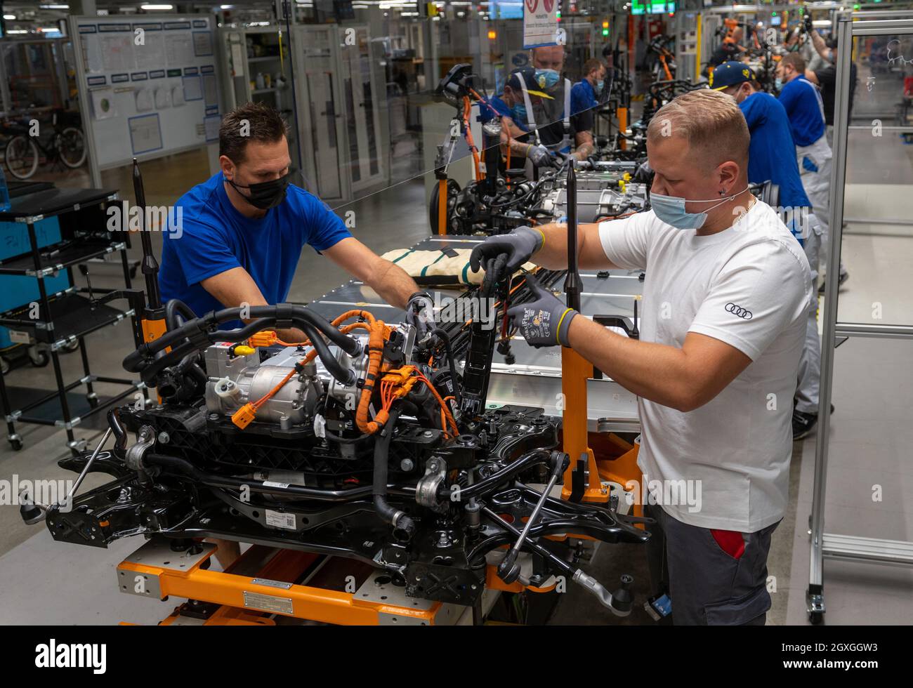 05 ottobre 2021, Sassonia, Zwickau: Nicky Richter (r), tecnico di meccatronica automobilistica presso Audi, assembla i treni motorizzati per i veicoli elettrici VW e Audi insieme ai dipendenti VW presso lo stabilimento Volkswagen di Zwickau. Sei mesi dopo il lancio del SUV, Zwickau è diventata il più grande sito di produzione di Audi per i veicoli elettrici. Oltre allo stabilimento VW di Zwickau, Audi costruisce anche veicoli completamente elettrici a Neckarsulm e Bruxelles. La prima auto elettrica prevista per la sede centrale di Ingolstadt è il Q6, che è previsto per il lancio sul mercato nel 2023. Audi tornò nel suo luogo di fondazione Foto Stock