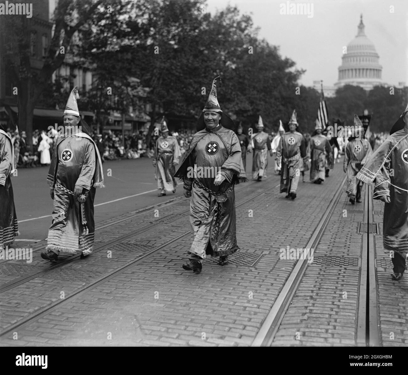 Foto d'epoca del 13 settembre 1926 che mostra i membri del Ku Klux Klan vestiti in abiti che passavano lungo Pennsylvania Avenue a Washington D.C. con la bandiera a stelle e a strisce e la cupola del Campidoglio sullo sfondo. A guidare la sfilata è Hiram Wesley Evans, Grand Wizard del KKK. Evans aveva condotto il rapimento e la tortura di un uomo nero mentre il capo del Dallas Klan Foto Stock Foto d'epoca del 13 settembre 1926 che mostra i membri del Ku Klux Klan vestiti in abiti che passavano lungo Pennsylvania Avenue a Washington D.C. con la bandiera a stelle e a strisce e la cupola del Campidoglio sullo sfondo. A guidare la sfilata è Hiram Wesley Evans, Grand Wizard del KKK. Evans aveva condotto il rapimento e la tortura di un uomo nero mentre il capo del Dallas Klan Foto Stock