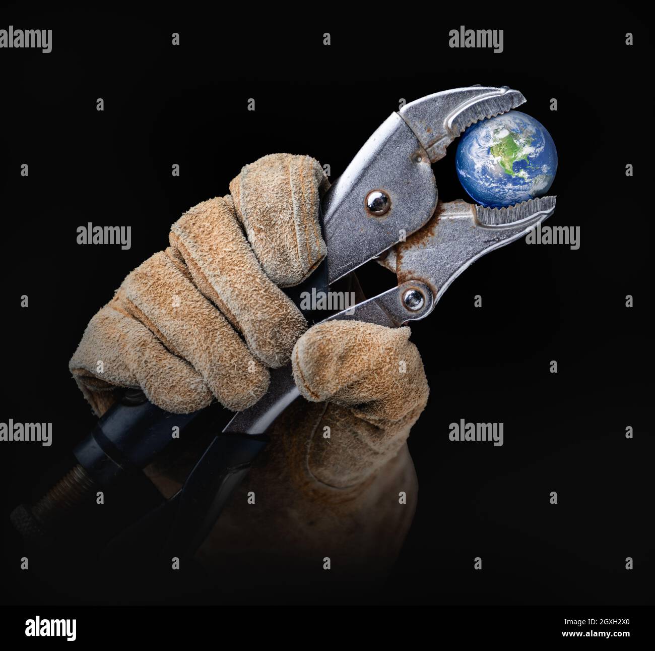 Lavoratore in edilizia Guanti che tiene pianeta Terra con morsa-grip chiave. Foto Stock