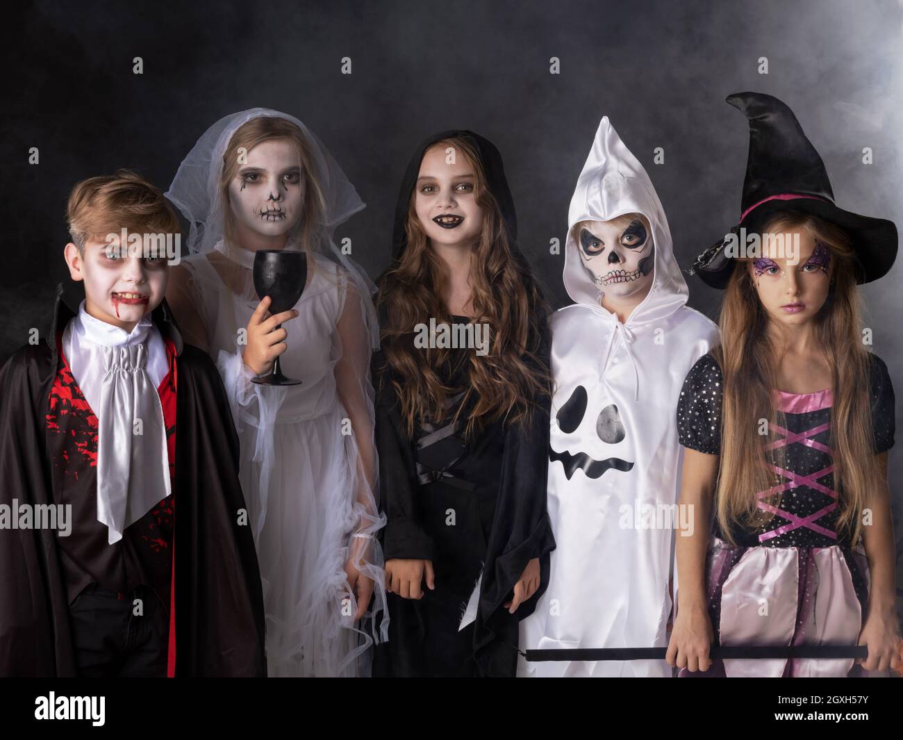 Buon Halloween partito con i bambini trucco o trattando in diversi costumi  fantasma, vampiro, scheletro, strega Foto stock - Alamy