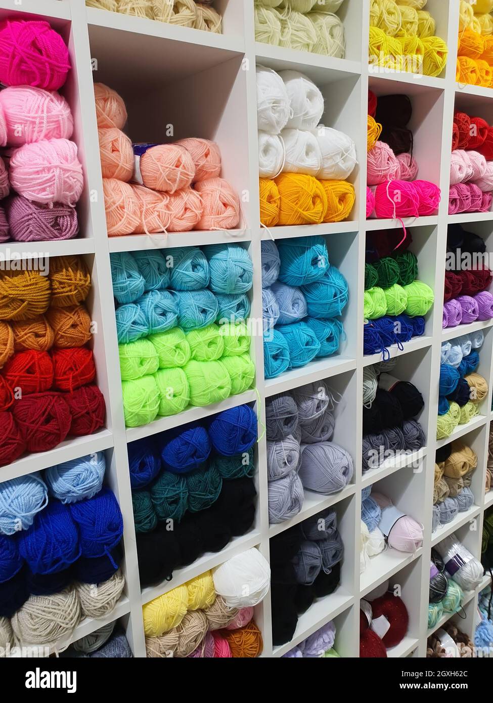Filati colorati di lana per maglieria su scaffali in haberdashery shop. Concetto artigianale di lavorazione a maglia Foto Stock