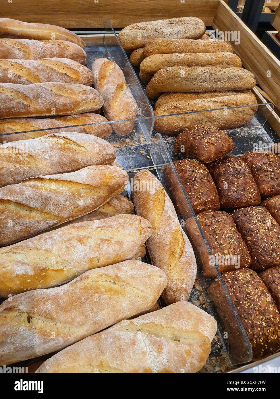 Varietà di diversi tipi di pane, baguette e panini hot dog in un panificio o negozio di alimentari. Primo piano appena sfornato Foto Stock