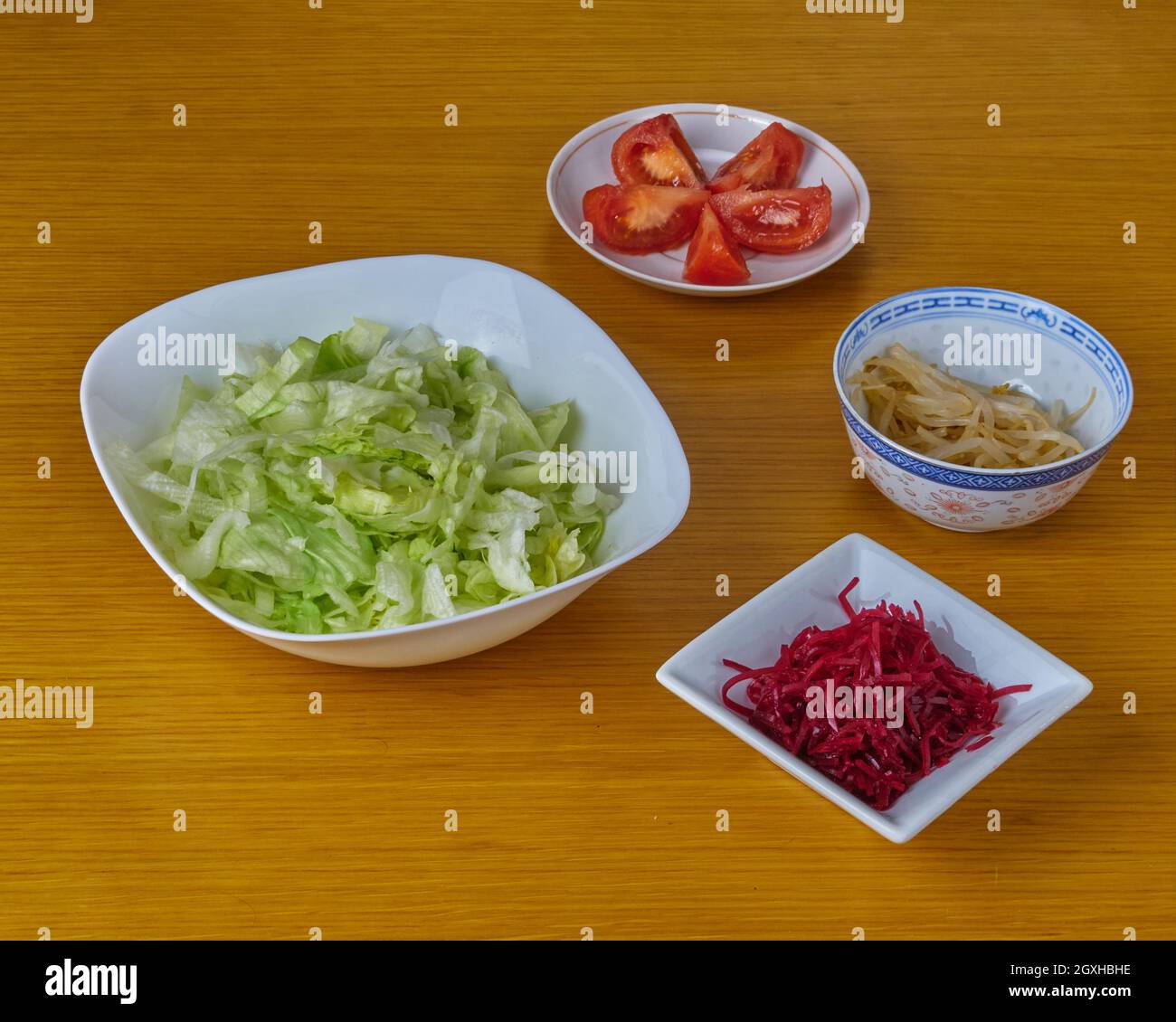 Ingredienti per la preparazione di insalata vegana verde su sfondo di legno. Foto Stock