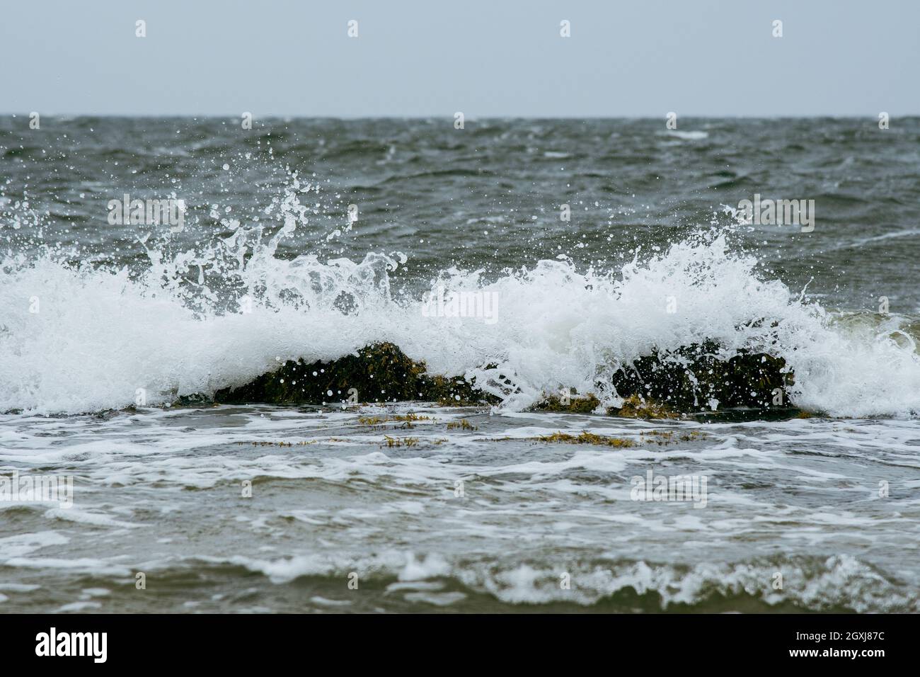 tempo tempestoso con la rottura delle onde in spiaggia Foto Stock