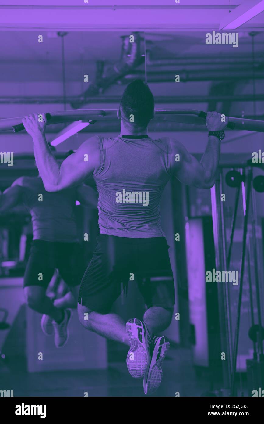 Forte bell'uomo che si esercita in palestra tono duo Foto Stock