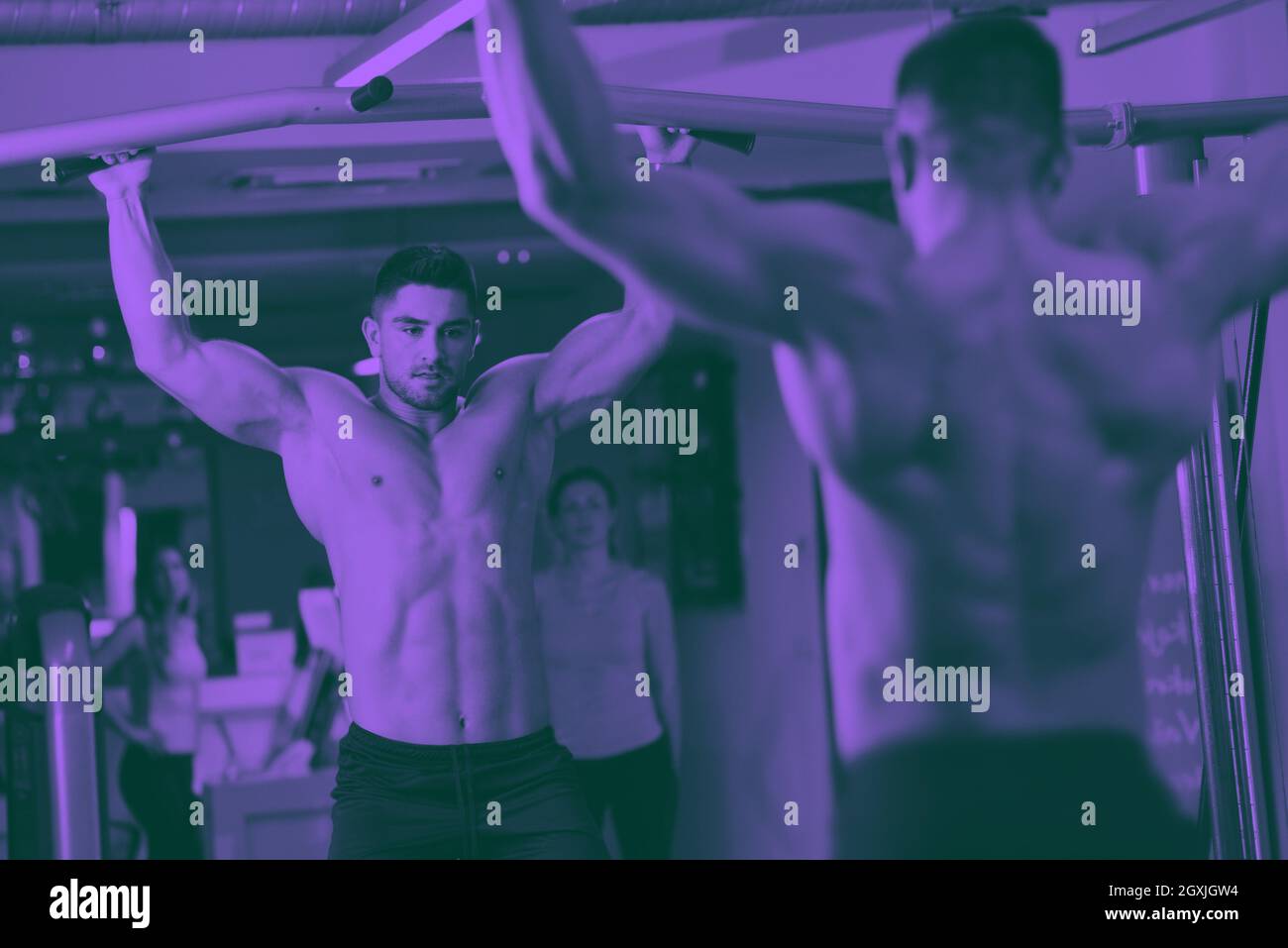 Forte bell'uomo che si esercita in palestra tono duo Foto Stock