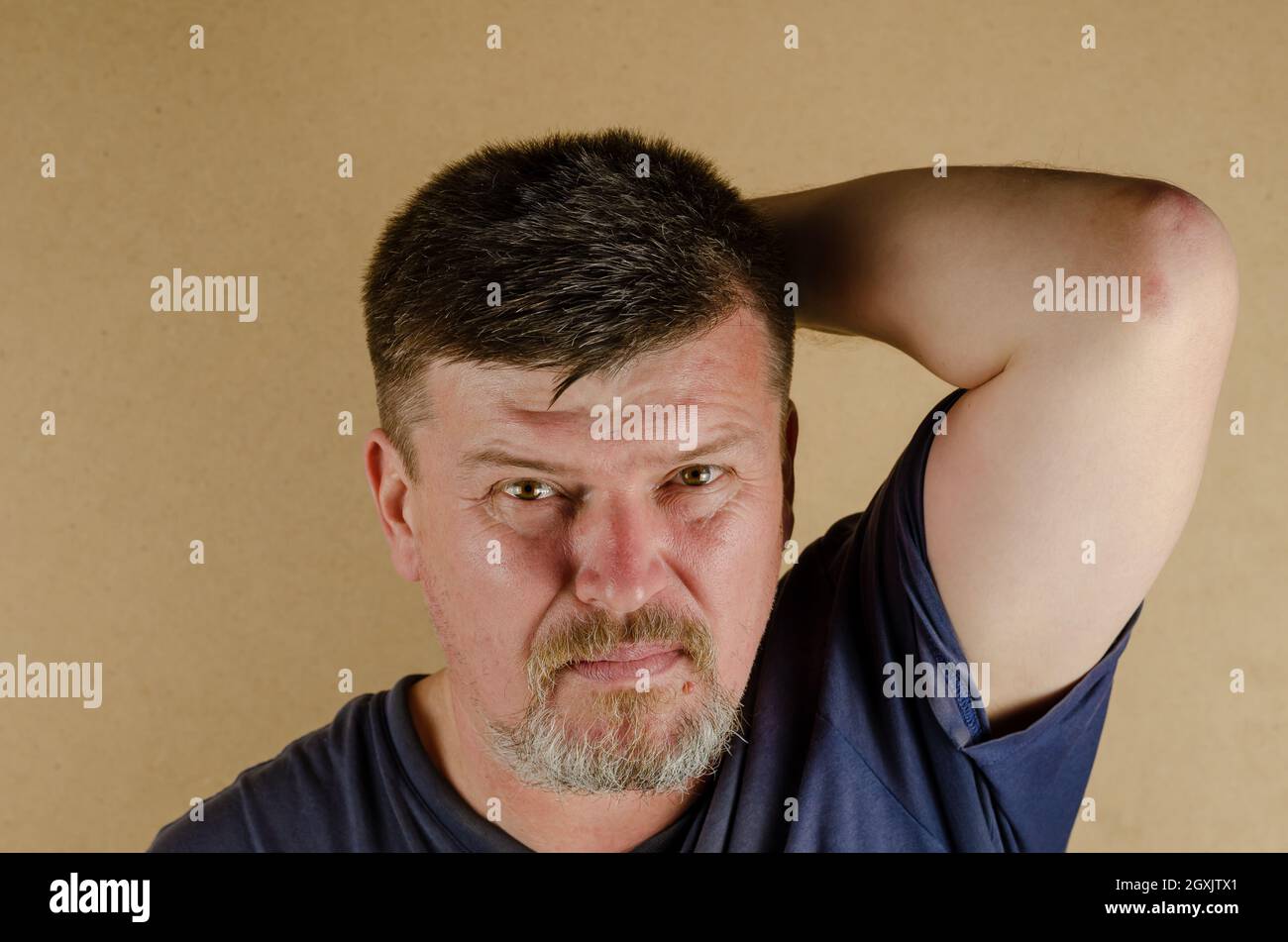 Ritratto di un uomo di 45 anni che guarda la fotocamera. Adulto non rasare il maschio in ambienti chiusi. Foto Stock