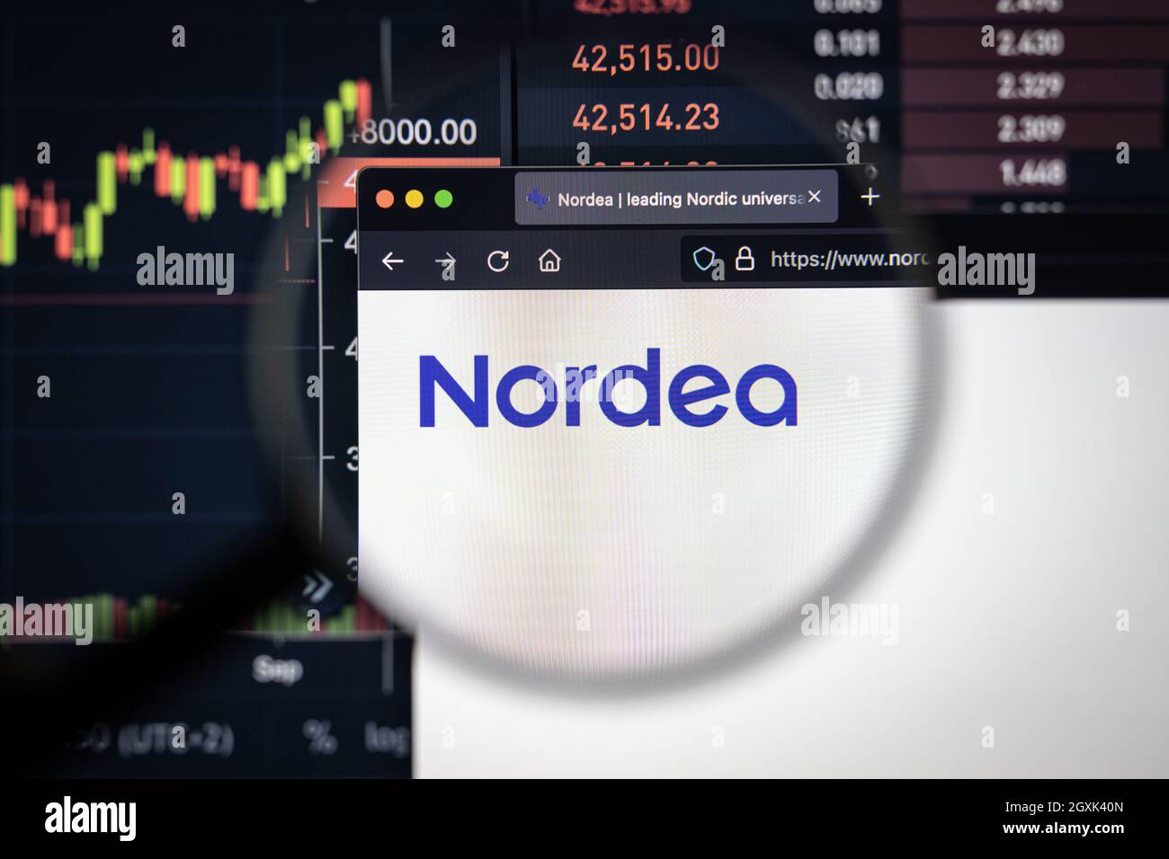 Nordea Company logo su un sito web con blurry mercato azionario sviluppi in background, visto su uno schermo di computer attraverso una lente d'ingrandimento Foto Stock