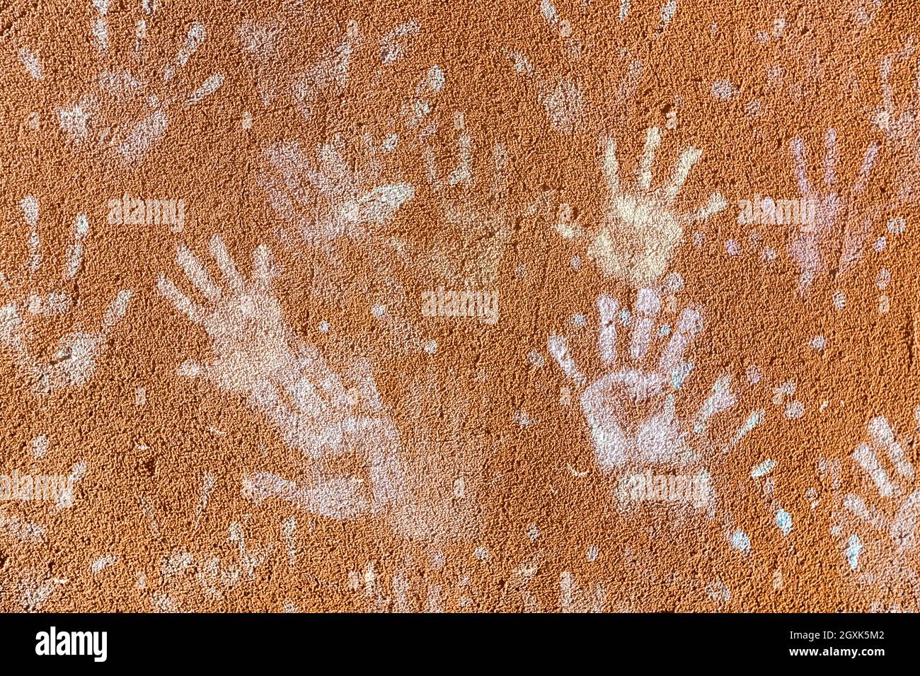 Giochi per bambini con gesso, colore della polvere dalle palme, come le stampe a mano sulla parete ruvida facciata sfondo, infanzia design. Foto Stock