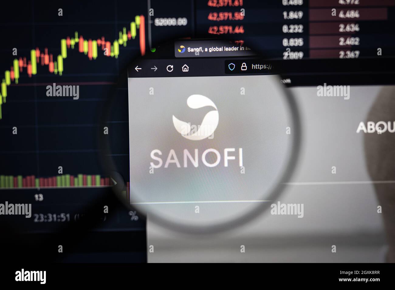 Sanofi Company logo su un sito web con blurry di mercato azionario sviluppi in background, visto su uno schermo di computer attraverso una lente d'ingrandimento Foto Stock