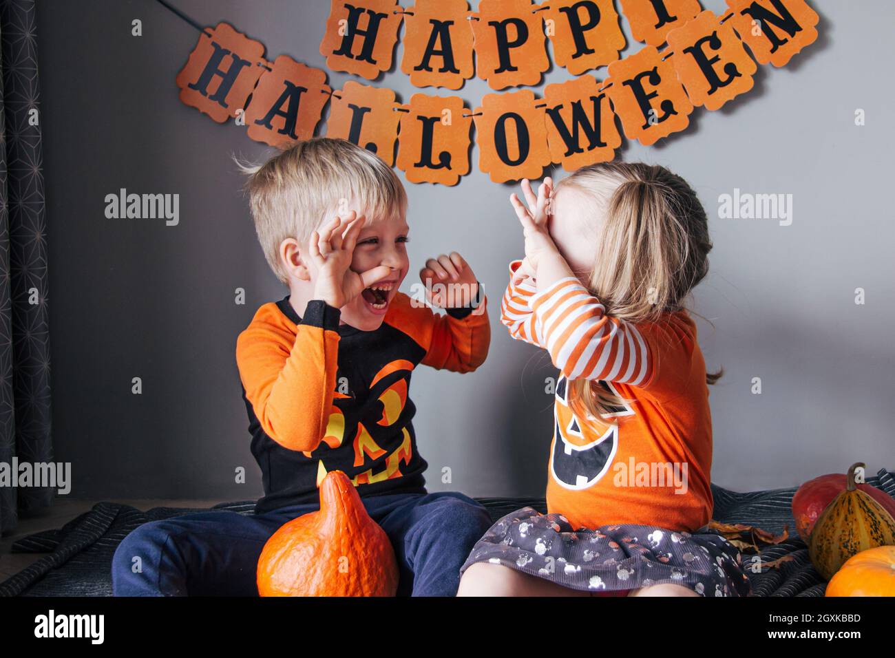 Una ragazza bionda piccola e un ragazzo in un costume di zucca per Halloween, trucco o trattare. I bambini festeggiano Halloween. Pronti per la vacanza trick o delizia Foto Stock