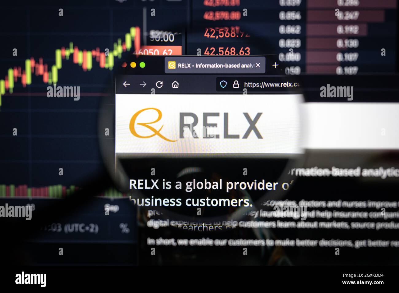 Logo aziendale RELX su un sito Web con sviluppi del mercato azionario sfocati sullo sfondo, visto su uno schermo del computer attraverso una lente d'ingrandimento Foto Stock