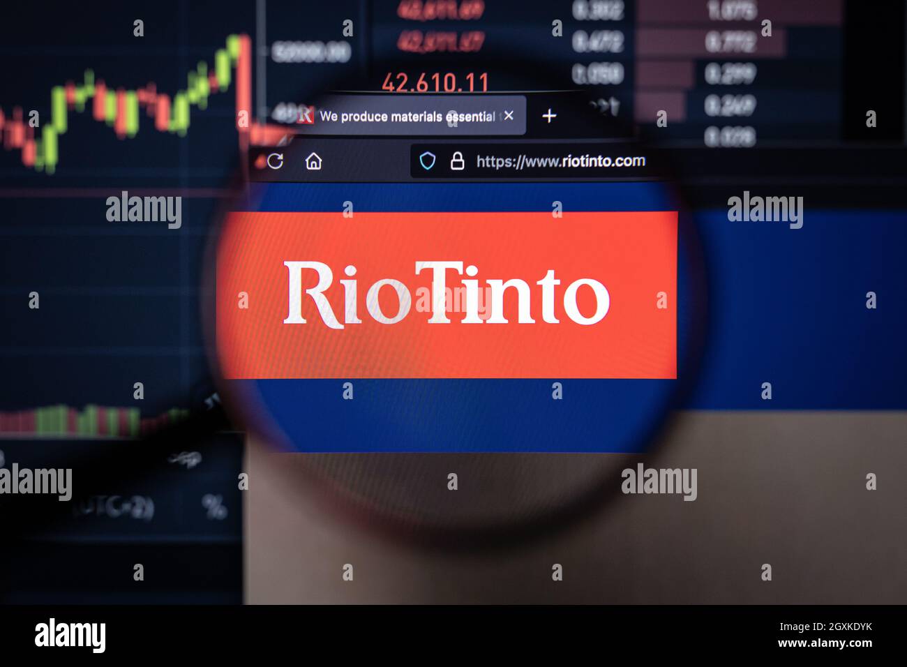 Rio Tinto Company logo su un sito web con blurry mercato azionario sviluppi in background, visto su uno schermo di computer attraverso una lente d'ingrandimento Foto Stock
