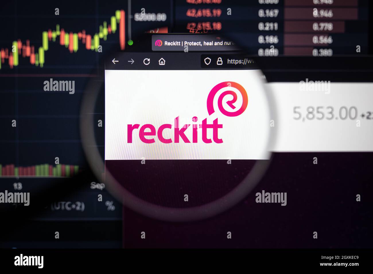 Reckitt Company logo su un sito web con blurry di mercato azionario sviluppi in background, visto su uno schermo di computer attraverso una lente d'ingrandimento Foto Stock