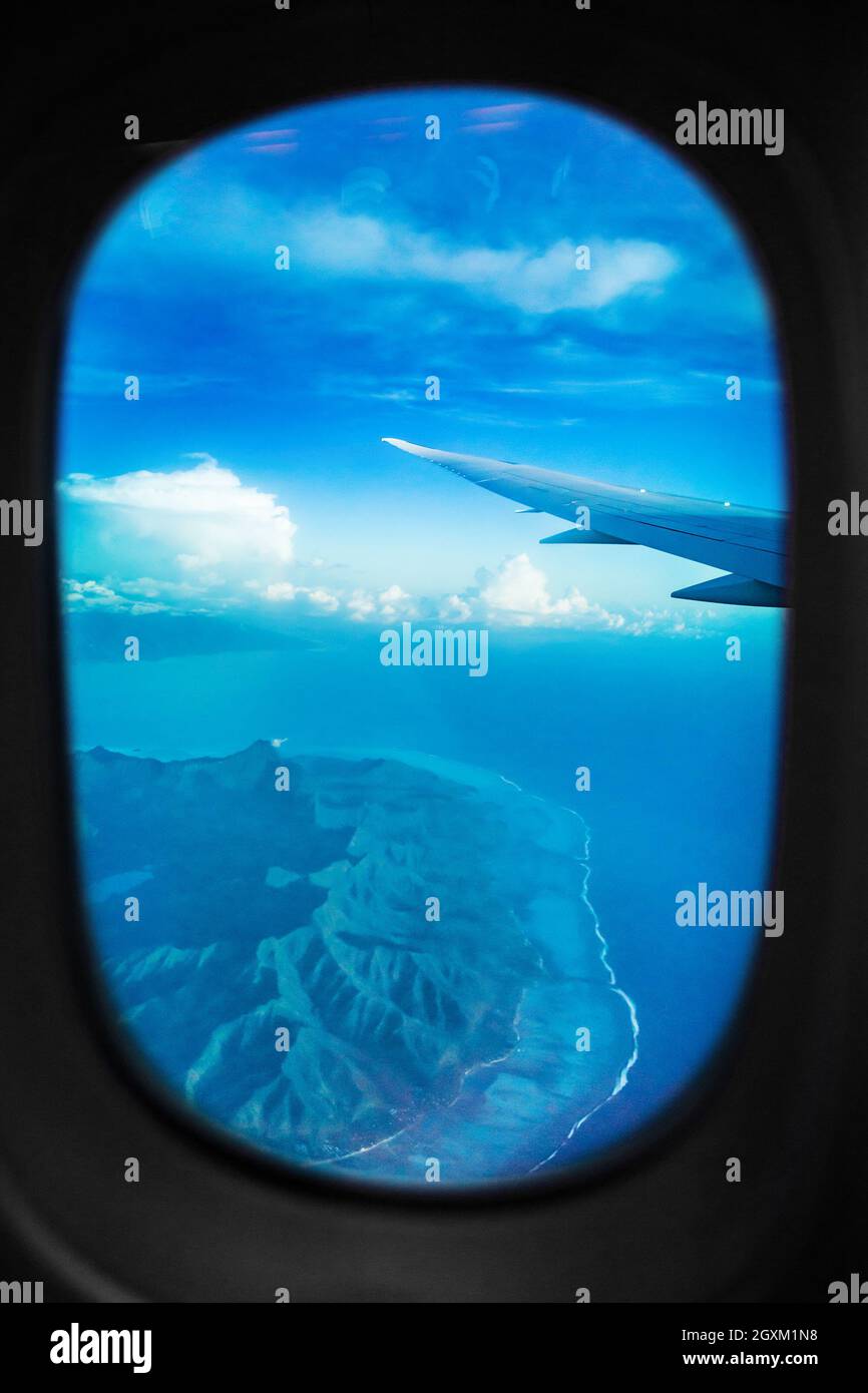 Vista in aereo dalla finestra durante il volo sopra l'isola di Tahiti. Paesaggio aereo dell'isola di Bora Bora, viaggio di vacanza in Polinesia Francese. Verticale Foto Stock