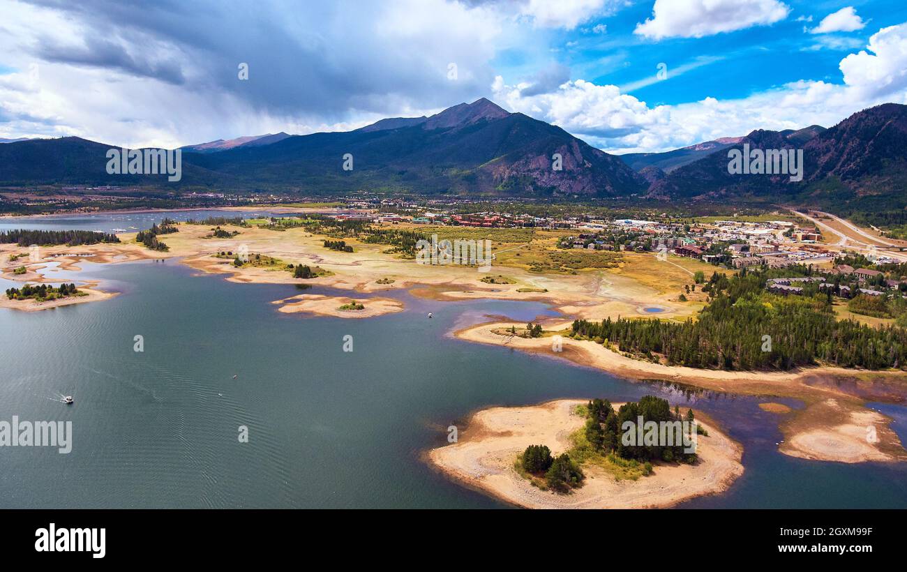 Lago con piccole isole vicino alla città e montagne nel deserto Foto Stock