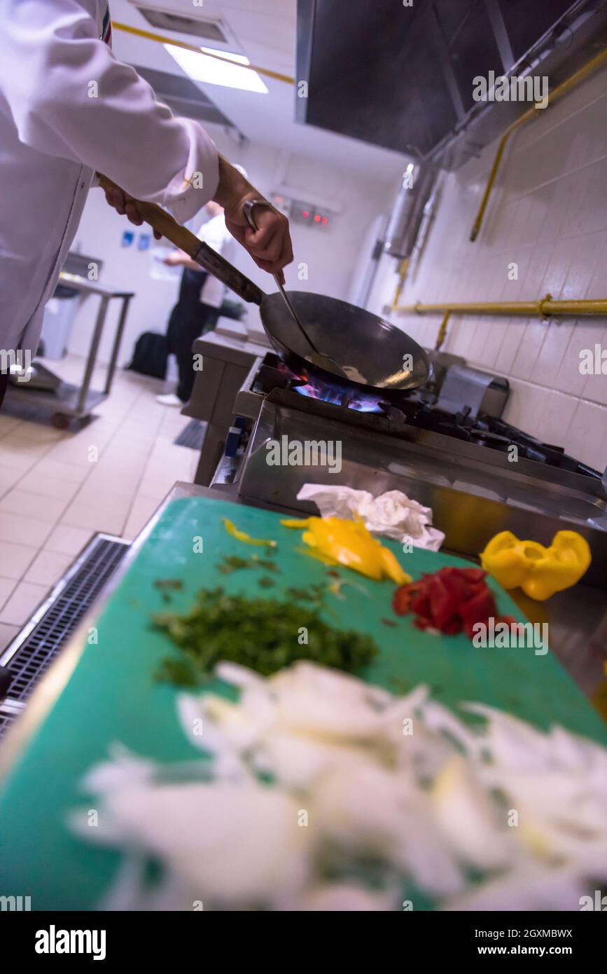 Lo chef prepara cibi, frittura in padella wok. La vendita e il concetto di cibo Foto Stock