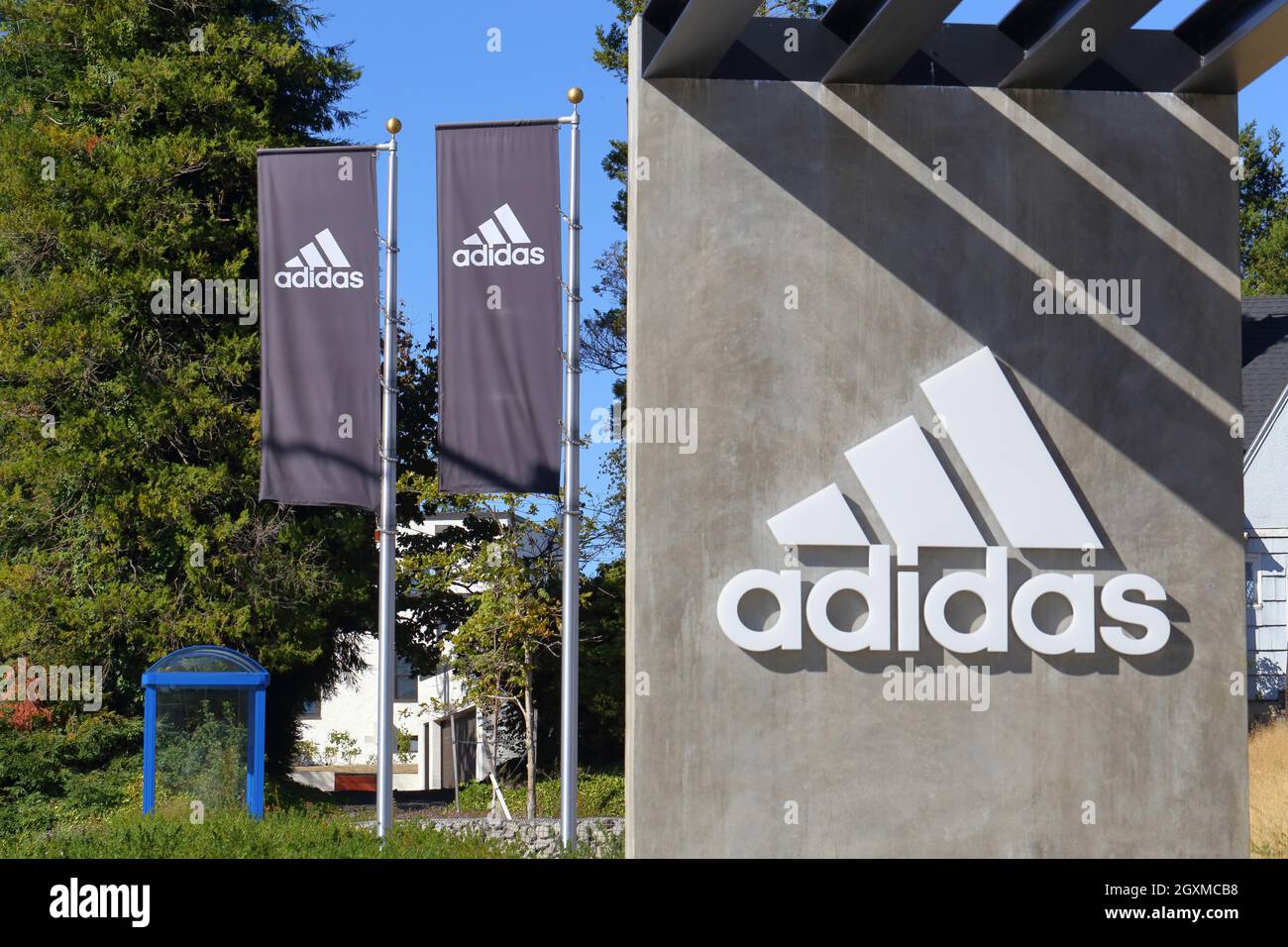 Ingresso all'Adidas Campus Expansion, 5060 N Greeley Ave, Portland, Oregon, con il logo Adidas sulle bandiere contro un cielo soleggiato. Foto Stock