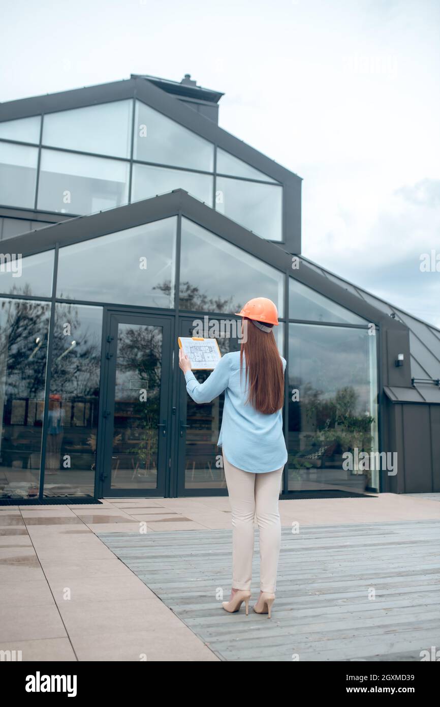 Donna che guarda l'edificio con ritorno alla macchina fotografica Foto Stock