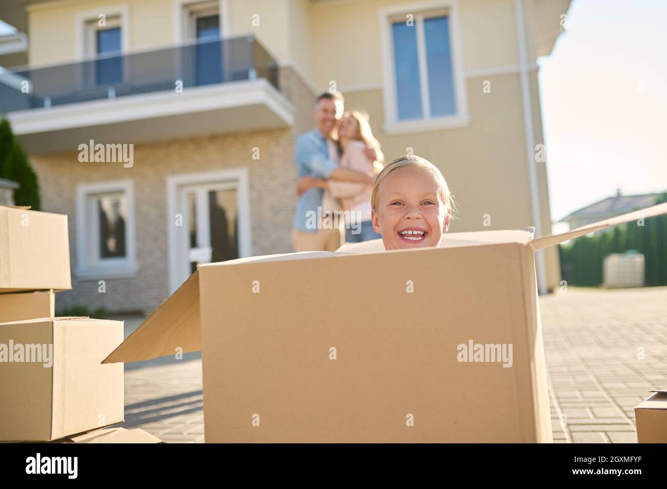 Ridendo bambina che guarda fuori dalla scatola grande Foto Stock