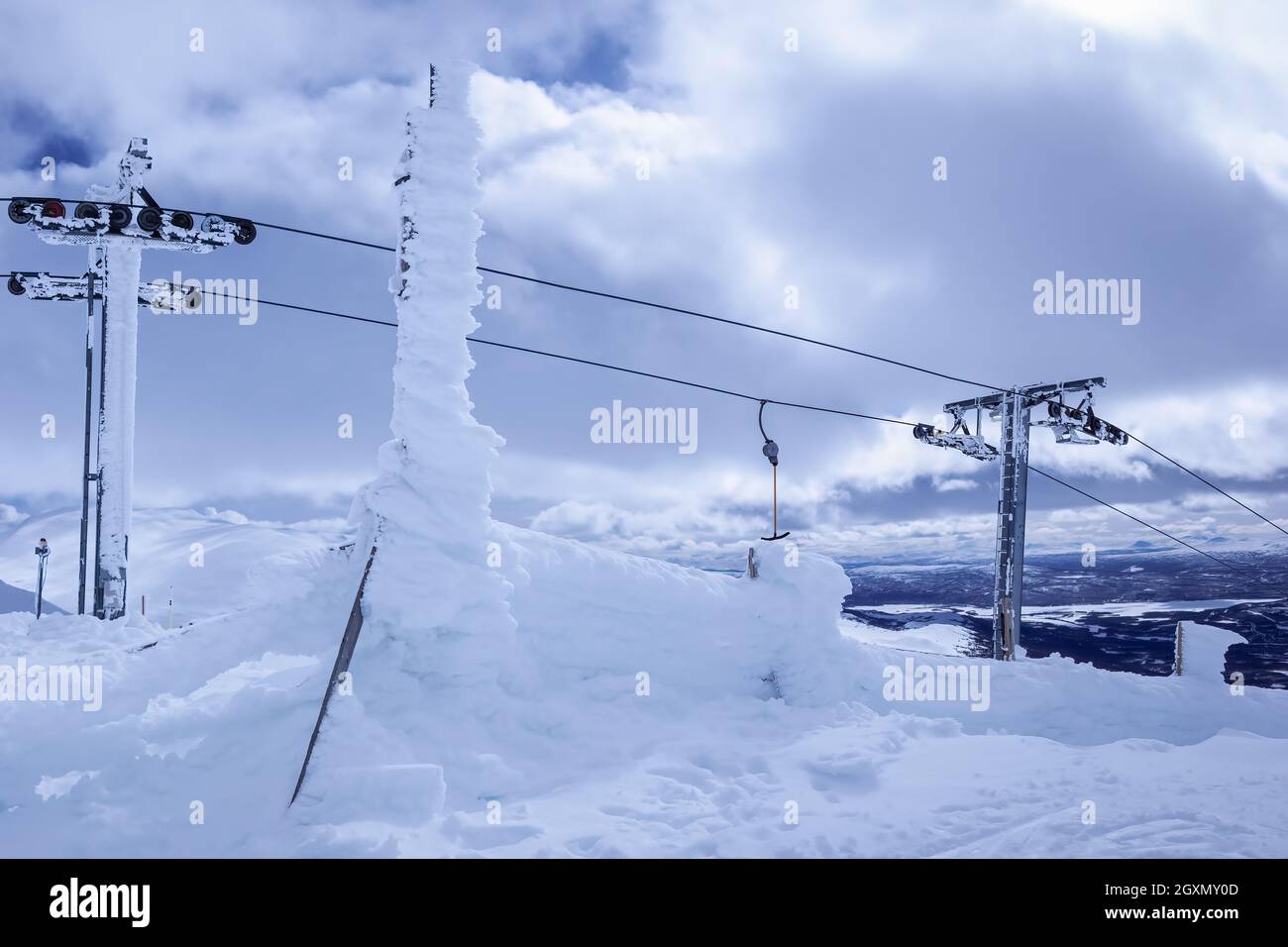 Ghiacciato sotto forte vento di neve, skilift in cima alla montagna, foto ravvicinata dell'attrezzatura per impianti di risalita della stazione sciistica Foto Stock