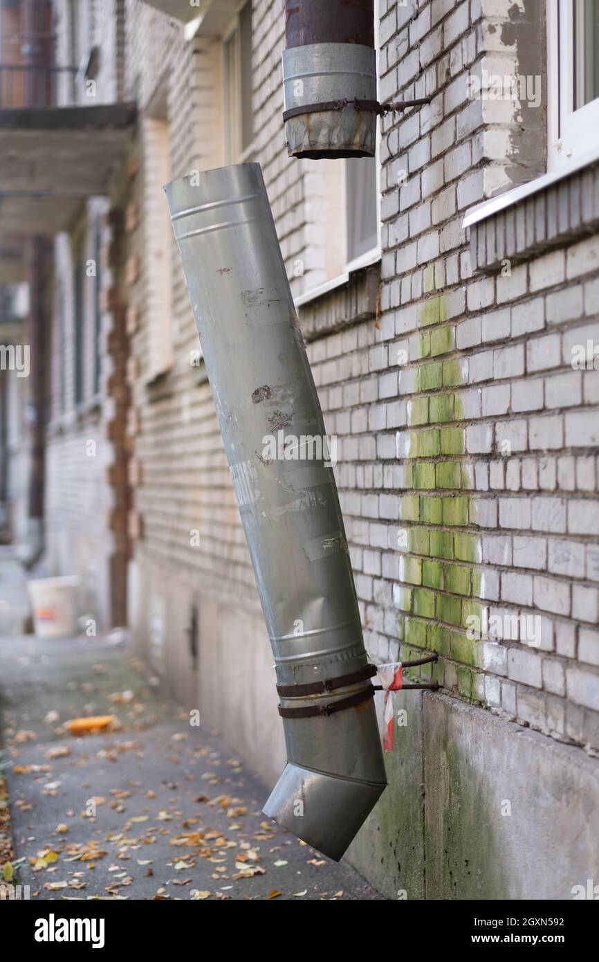 Tubo di drenaggio danneggiato e rotto per l'acqua piovana sul muro della casa. Foto Stock