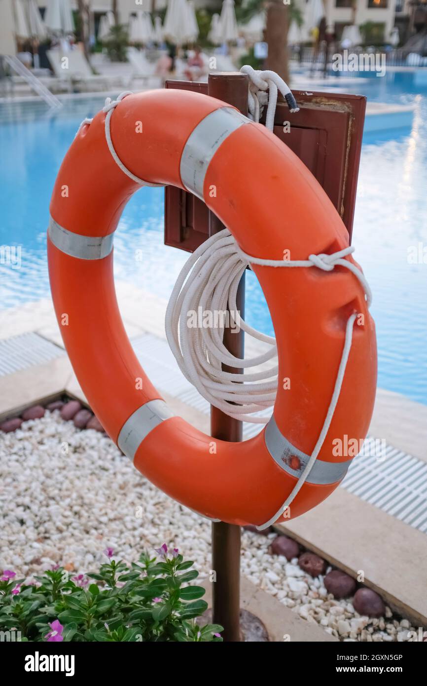 Salvavita rossa e corde per salvare vite umane quando annegano le persone vicino alla piscina. Foto Stock