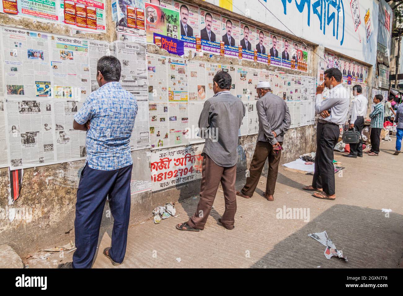 DHAKA, BANGLADESH - 20 NOVEMBRE 2016: La gente sta leggendo il quotidiano pubblicato su un muro a Dhaka, Bangladesh Foto Stock
