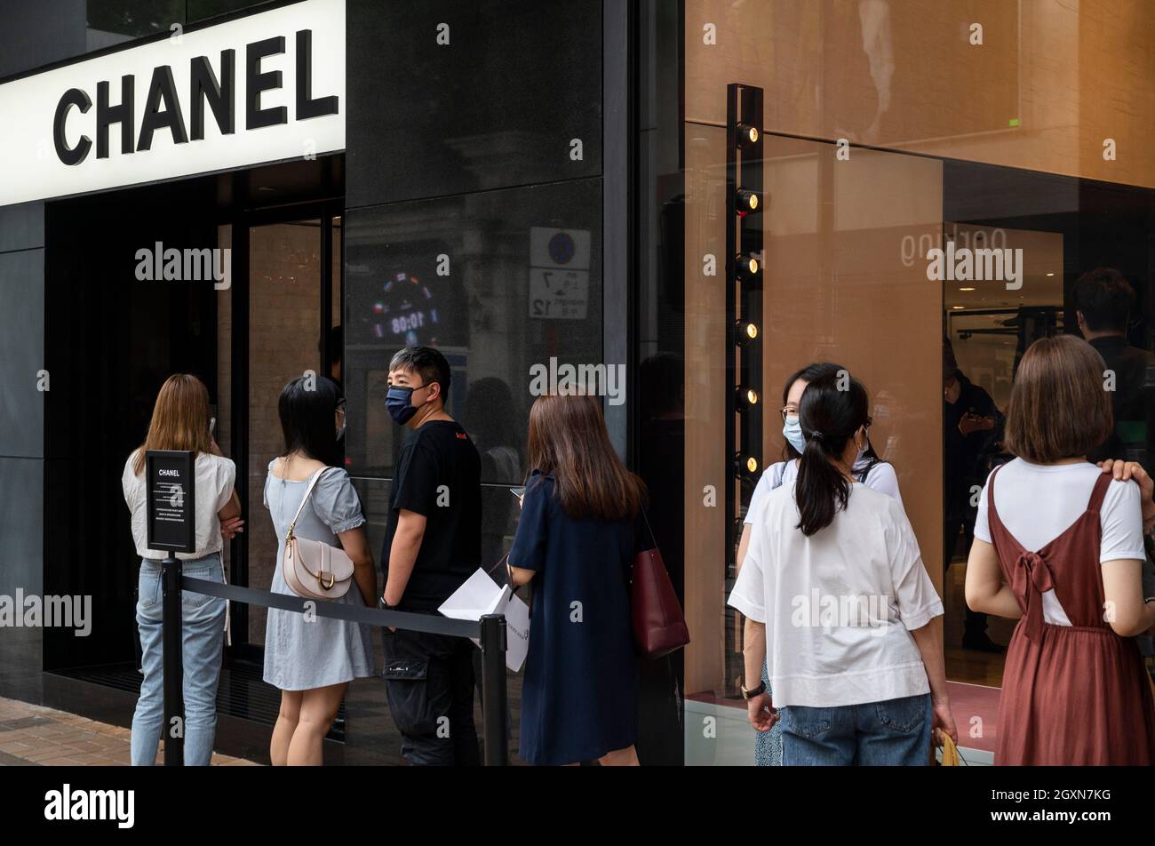Gli acquirenti fanno la fila all'ingresso del negozio di abbigliamento e prodotti di bellezza Chanel, multinazionale francese, visto a Hong Kong. Foto Stock