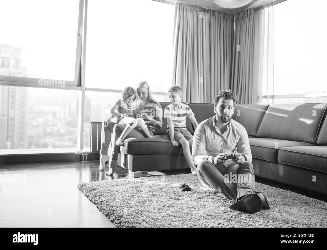 La famiglia felice. Padre, madre e figli la riproduzione di un video gioco di padre e figlio di giocare con i videogiochi insieme sul pavimento Foto Stock