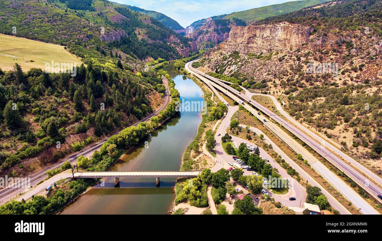 Antenna di maestose montagne rocciose canyon con strade e binari ferroviari Foto Stock