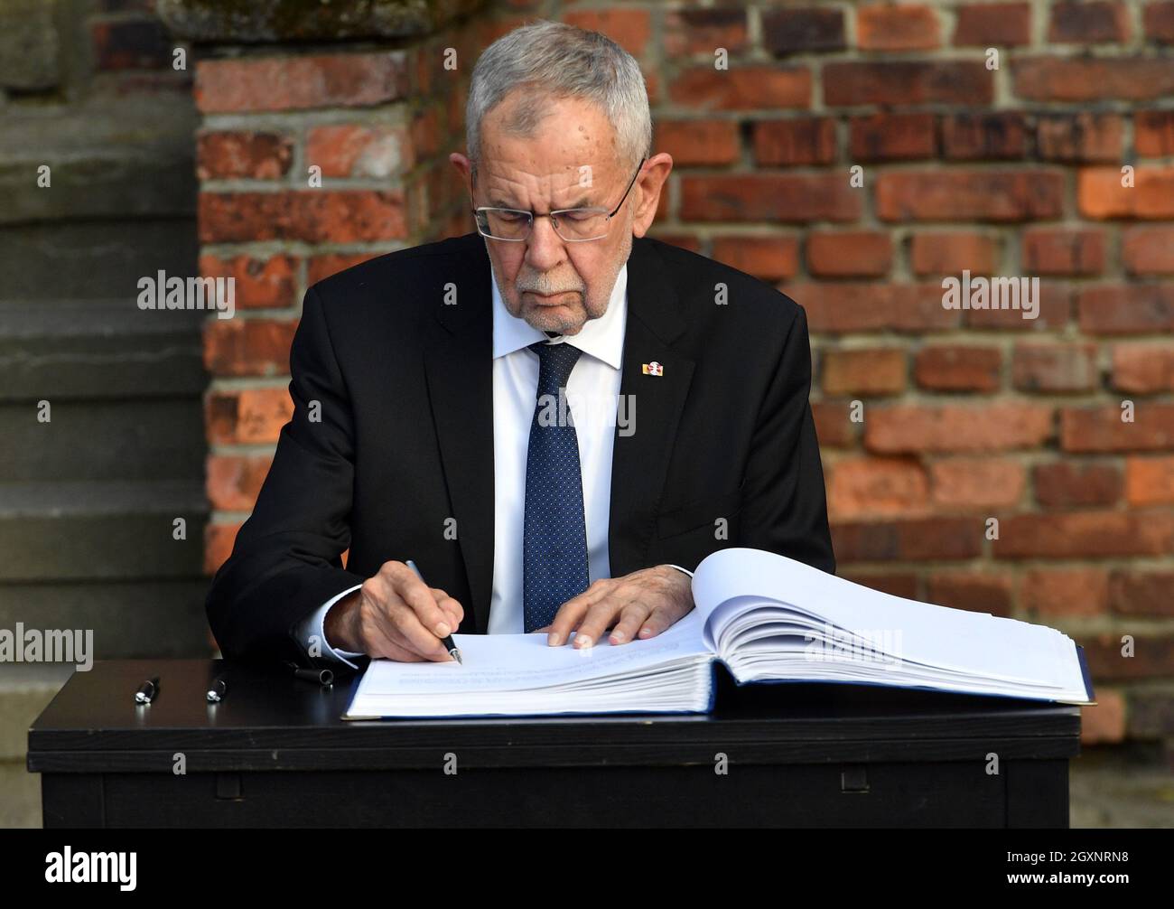 Oswiecim, Polonia. 4 ottobre 2021. Il presidente austriaco Alexander Van der Bellen firma il libro commemorativo. Il presidente austriaco Alexander Van der Bellen e il presidente del Consiglio nazionale austriaco Wolfgang Sobotka hanno visitato il sito commemorativo di Auschwitz e hanno partecipato all'apertura della mostra nazionale austriaca intitolata 'so far, so Close. Austria e Auschwitz». Credit: SOPA Images Limited/Alamy Live News Foto Stock