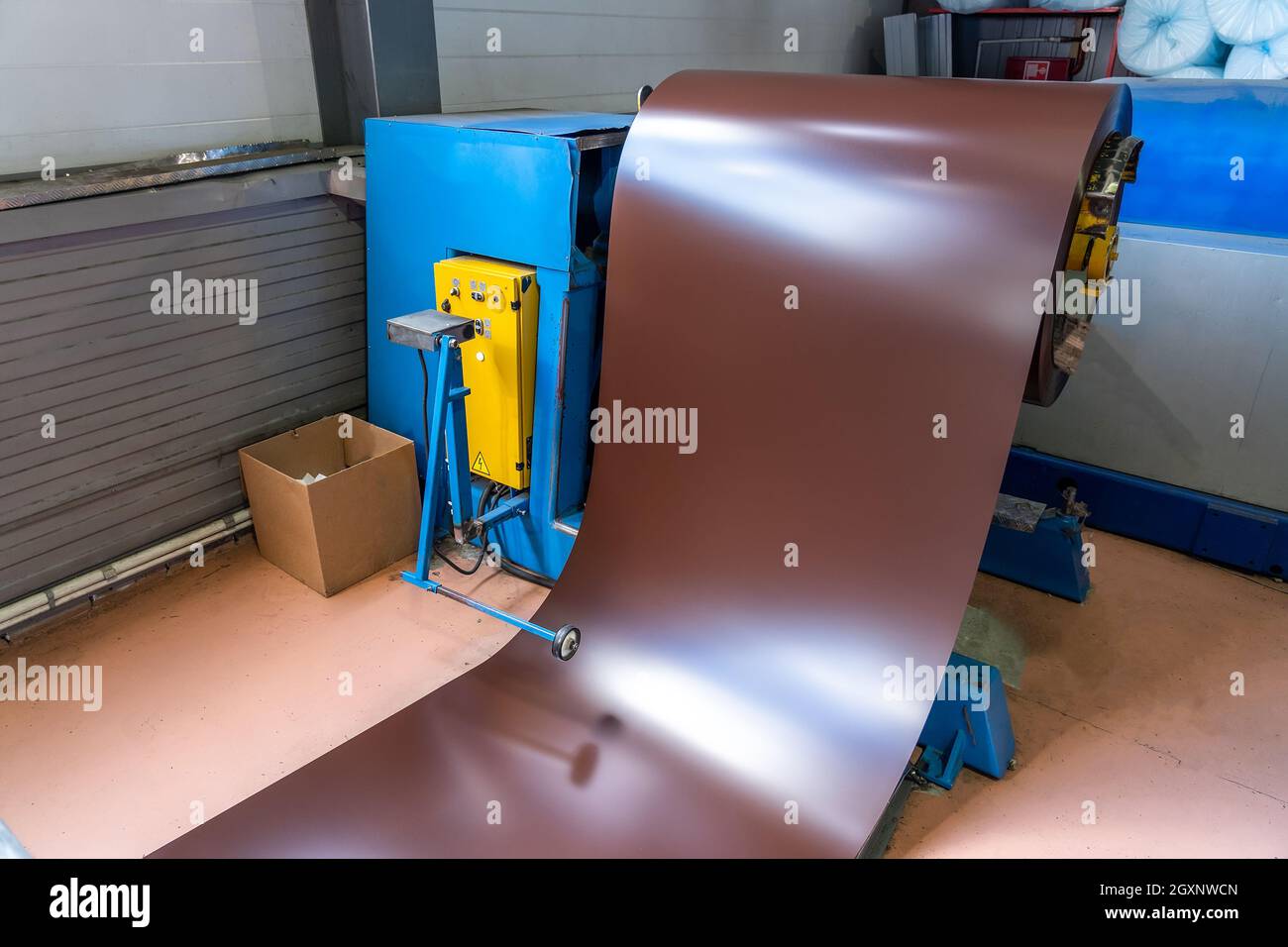 Rotolo di lamiera zincata verniciata in macchina da taglio, ferreria e lavorazione dei metalli in fabbrica. Foto Stock