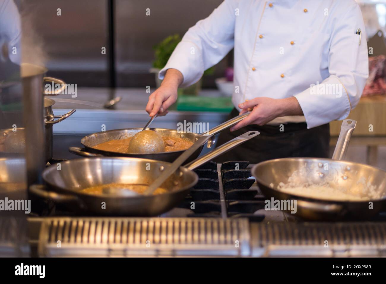 Lo chef prepara cibi, frittura in padella wok. La vendita e il concetto di cibo Foto Stock