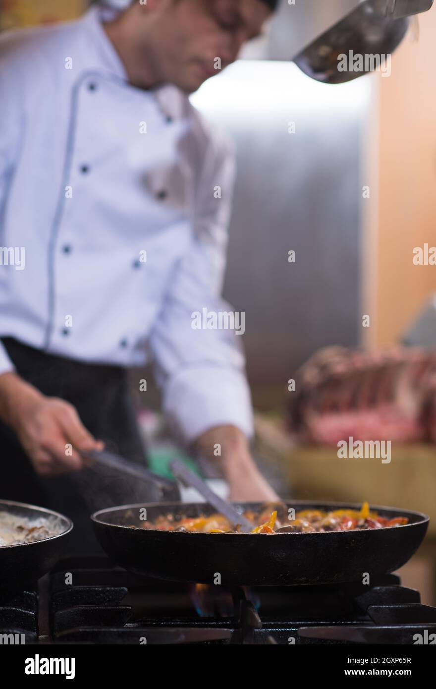 Lo chef prepara cibi, frittura in padella wok. La vendita e il concetto di cibo Foto Stock