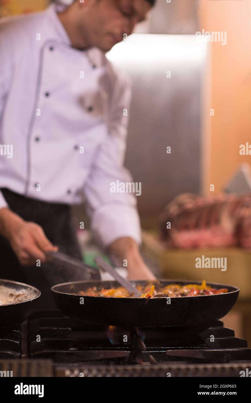 Lo chef prepara cibi, frittura in padella wok. La vendita e il concetto di cibo Foto Stock