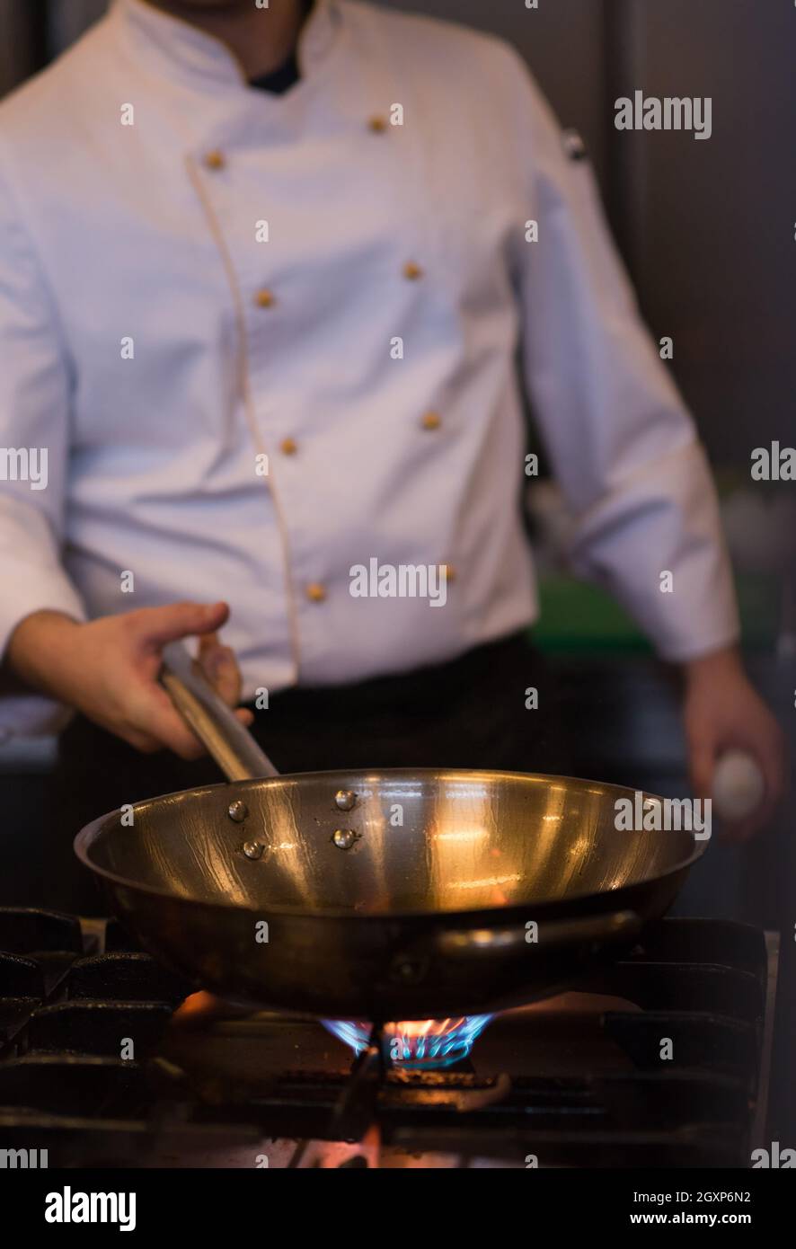 Lo chef prepara cibi, frittura in padella wok. La vendita e il concetto di cibo Foto Stock