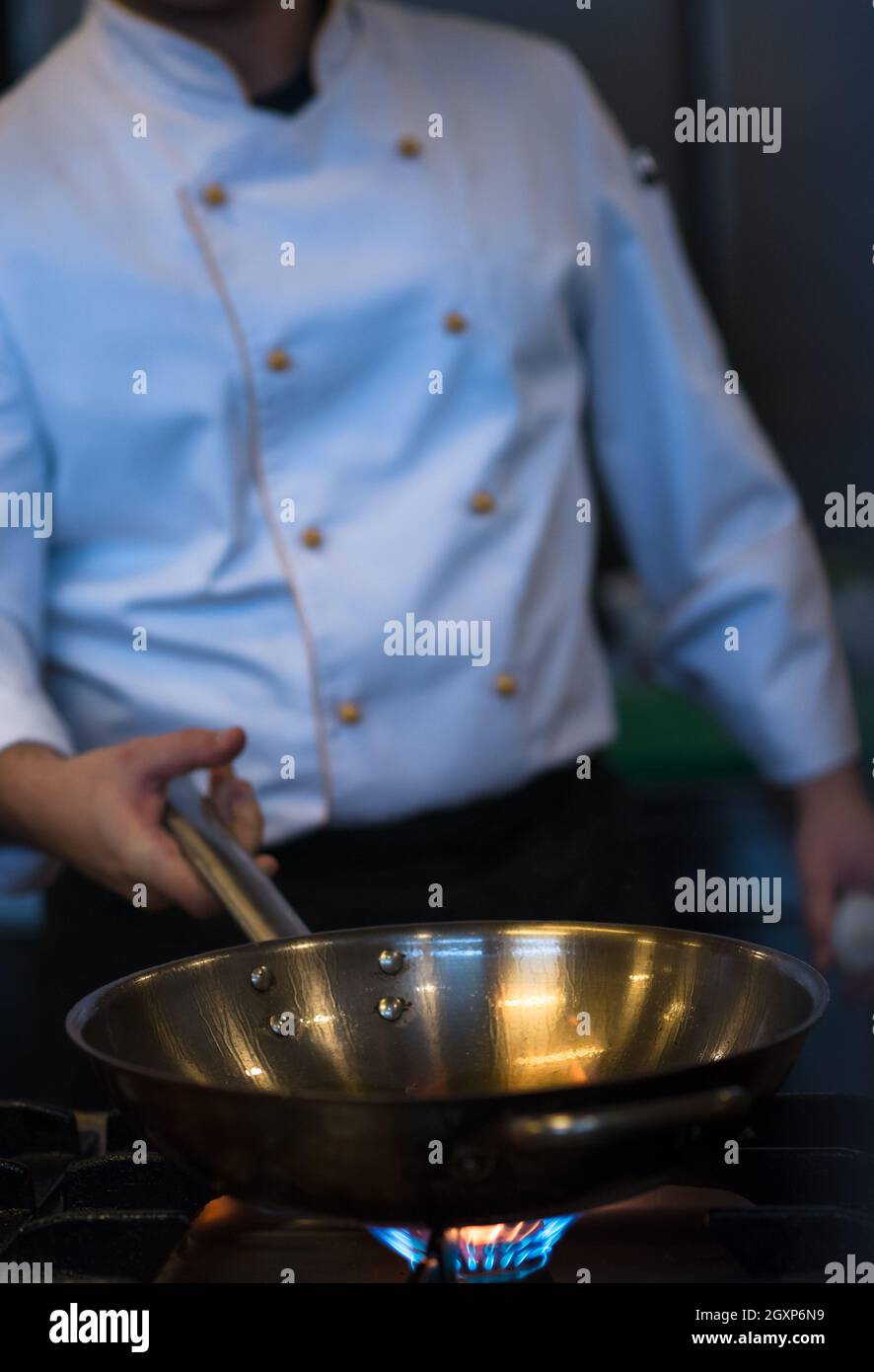 Lo chef prepara cibi, frittura in padella wok. La vendita e il concetto di cibo Foto Stock