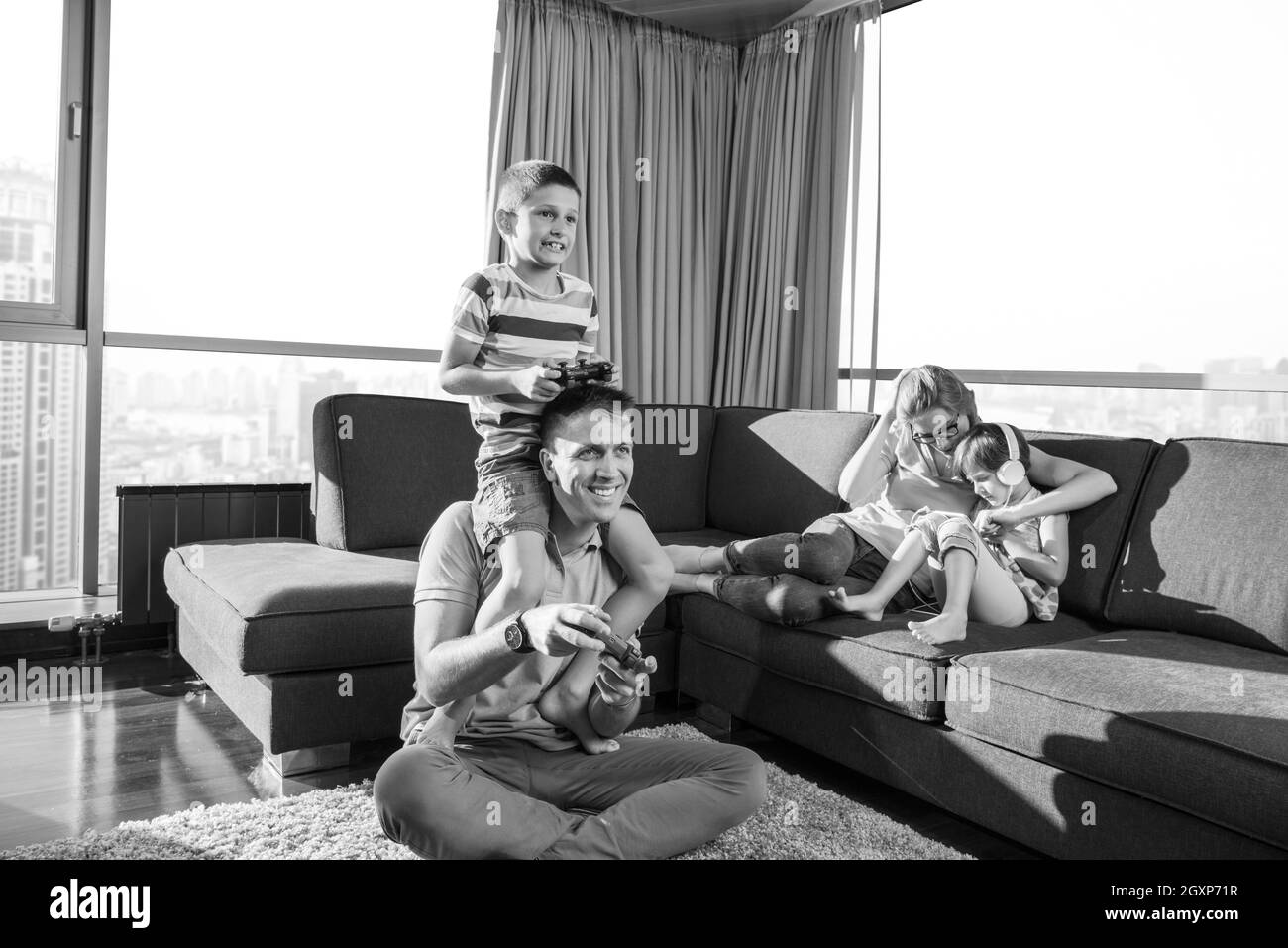 La famiglia felice. Padre, madre e figli la riproduzione di un video gioco di padre e figlio di giocare con i videogiochi insieme sul pavimento Foto Stock