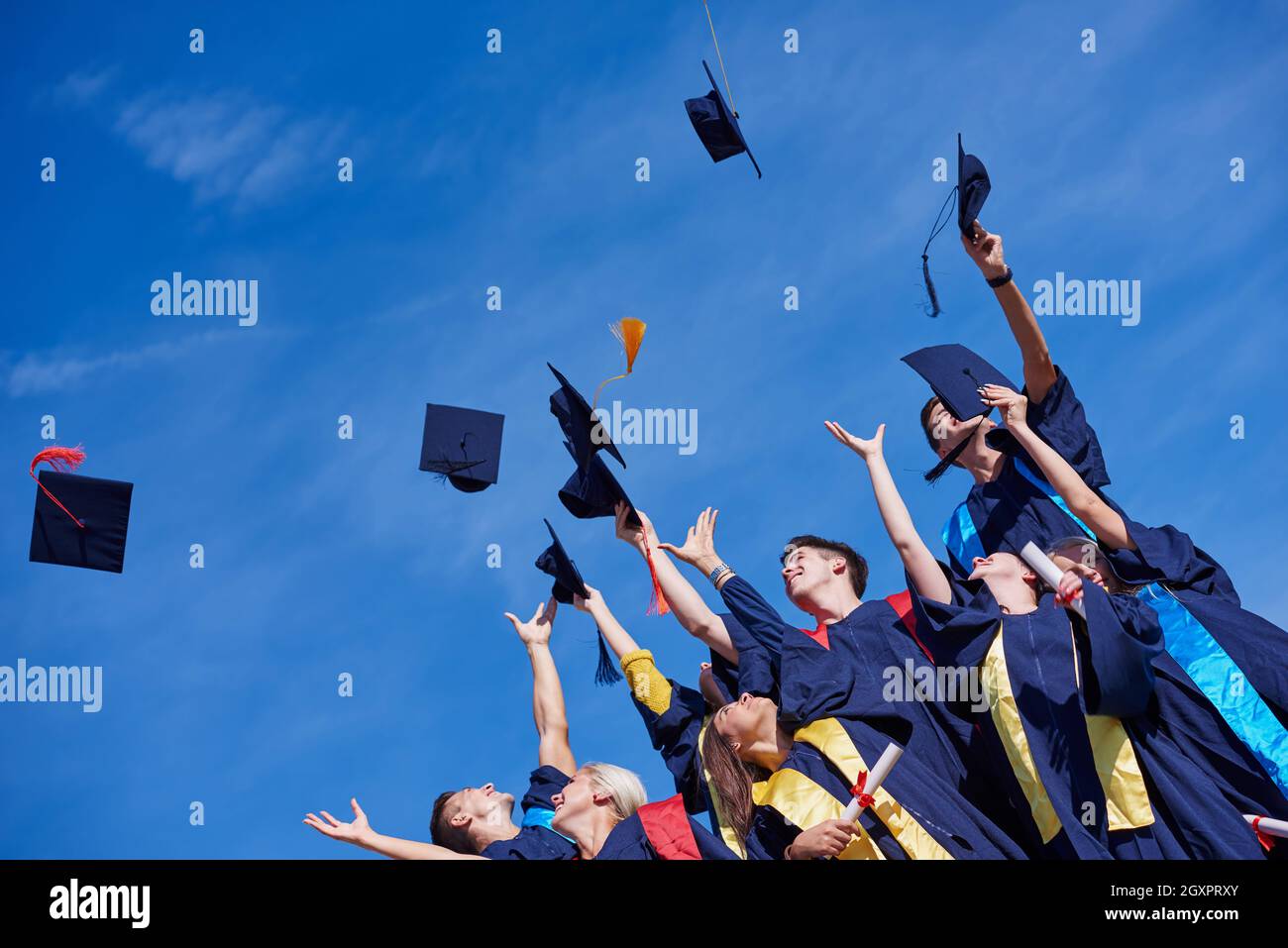 Alta scuola gli studenti laureati tossing fino cappelli oltre il cielo blu  Foto stock - Alamy