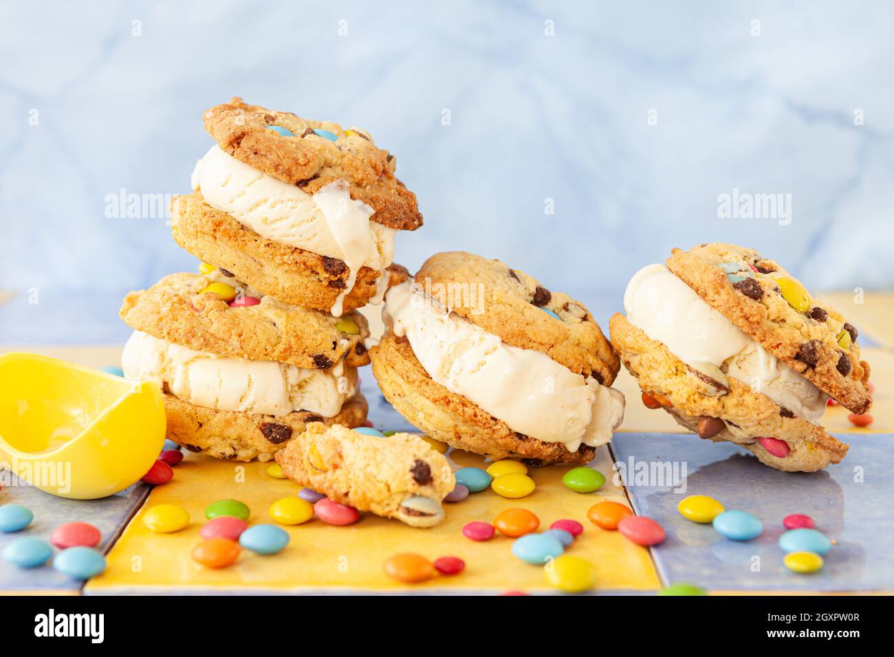 Panino gelato alla vaniglia con biscotti al cioccolato e colorato lenticchie di cioccolato Foto Stock