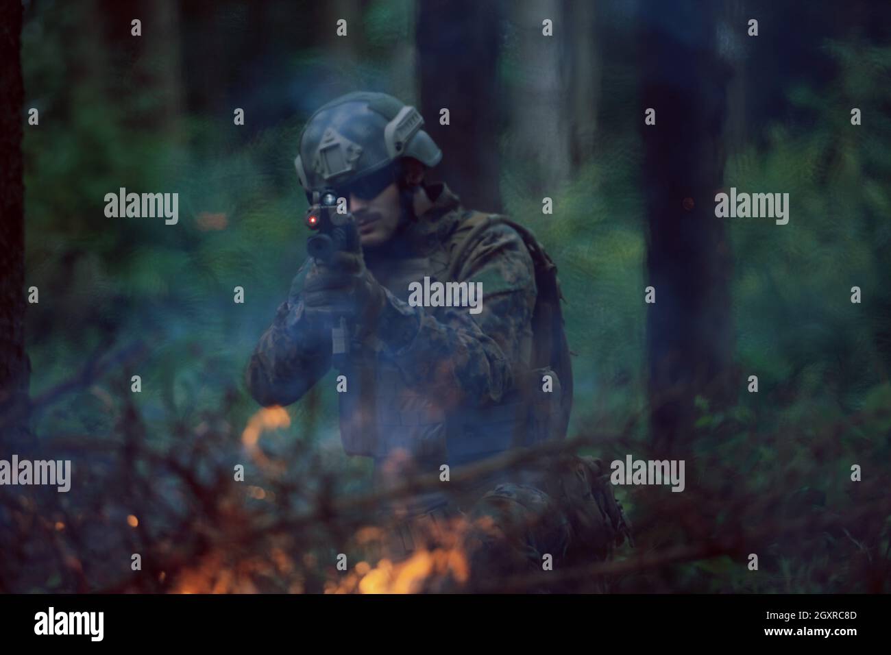 un moderno soldato di guerra in azione che punta all'arma ottica a vista laser in posizione di combattimento mentre cerca un bersaglio in battaglia Foto Stock