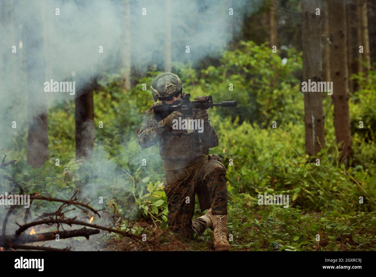 un moderno soldato di guerra in azione che punta all'arma ottica a vista laser in posizione di combattimento mentre cerca un bersaglio in battaglia Foto Stock