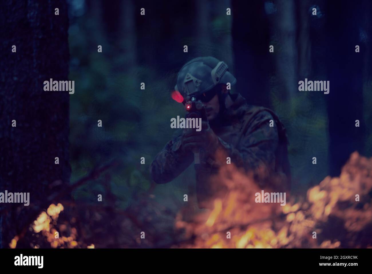 un moderno soldato di guerra in azione che punta all'arma ottica a vista laser in posizione di combattimento mentre cerca un bersaglio in battaglia Foto Stock